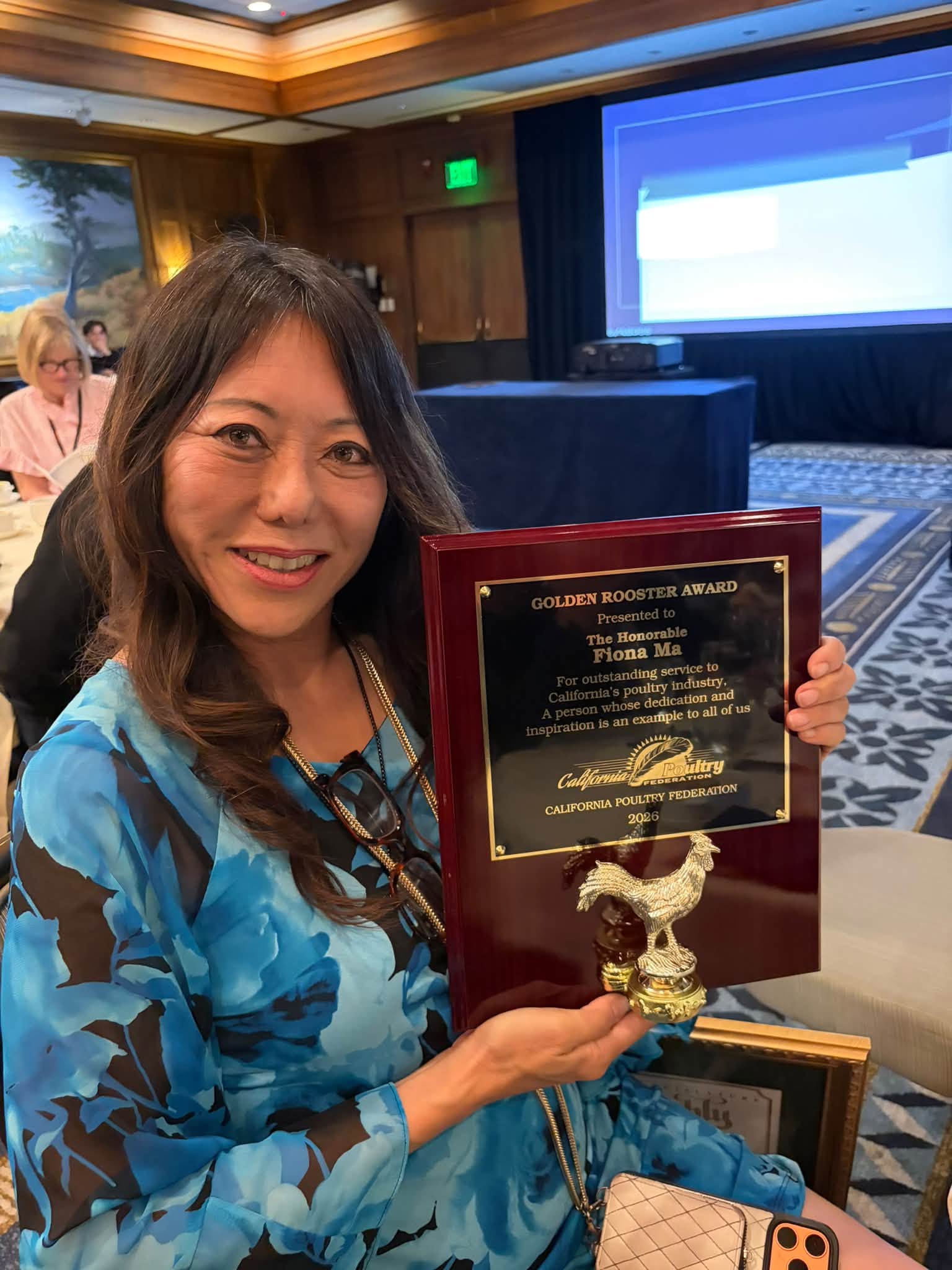 Fiona Ma holding the California Poultry Association Golden Rooster Award